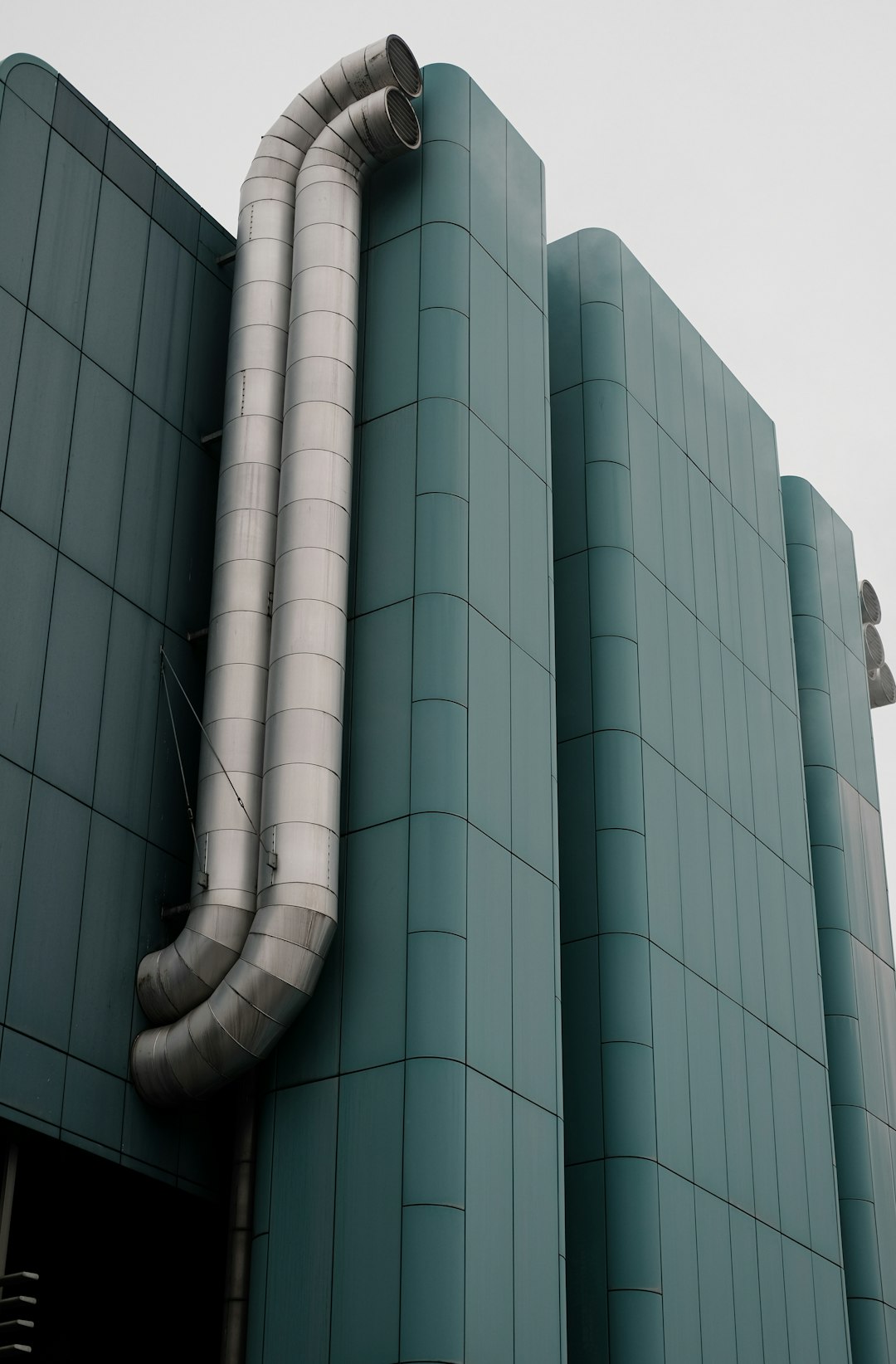 a-large-metal-pipe-is-attached-to-the-side-of-a-building-s-6dvwaewdm